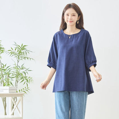 Mikonosublue Storeのネイビーの5分袖Aライントップスを着用した女性。バックフリルが特徴の体型カバーできる夏用ブラウス。
