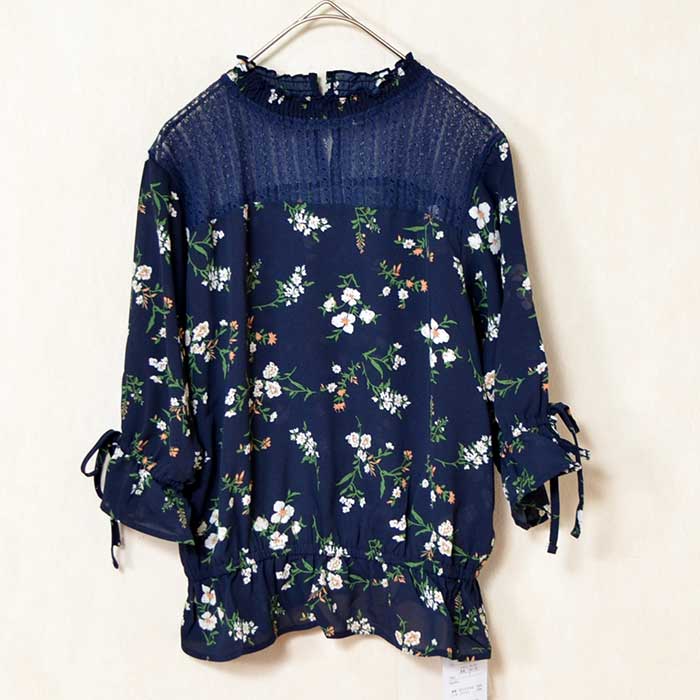 Mikonosublue Storeのネイビー花柄ジョーゼットブラウス。デコルテのシアーレースと袖口のリボンが上品な七分袖トップス。