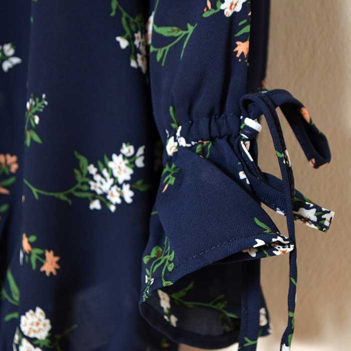 Mikonosublue Storeのネイビー花柄ジョーゼットブラウス。袖口にリボンが付いた七分袖のキャンディースリーブデザイン。