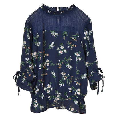 Mikonosublue Storeのネイビー花柄ジョーゼットブラウス。デコルテのシアーレースと袖口のリボンが上品な七分袖トップス。