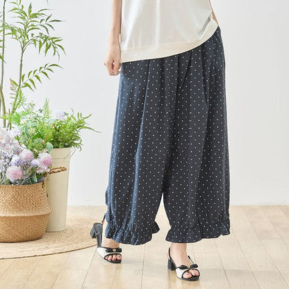 Mikonosublue Storeのピンドット柄ワイドパンツ。裾のギャザーフリルが特徴的なネイビーのゆったりとしたポリエステル製ボトムス。