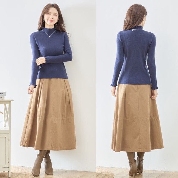 Mikonosublue Storeのネイビーのリブニットプルオーバー。首元と袖口のフリルが特徴のハイネック長袖トップス。