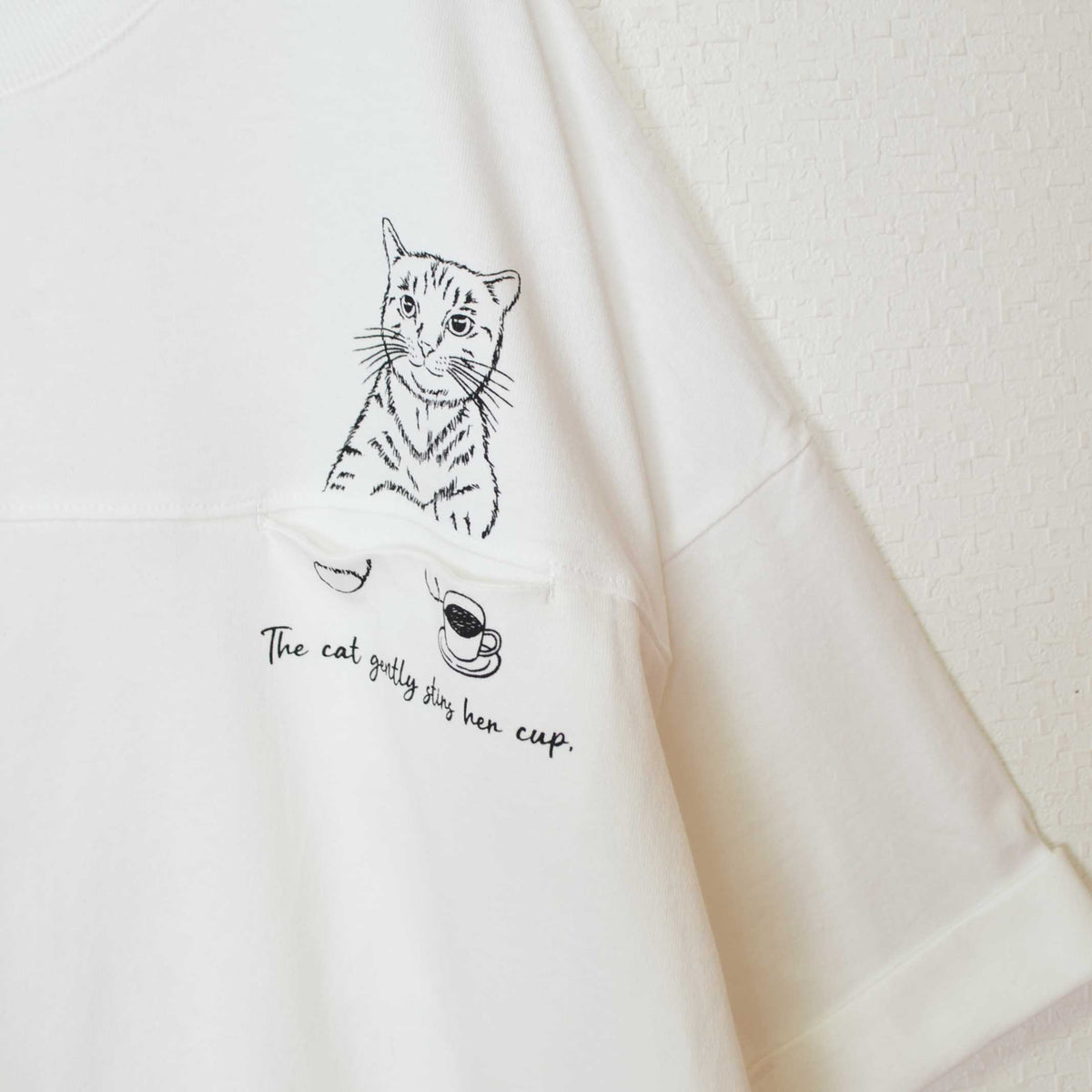 Mikonosublue Storeの猫プリントが施された白の綿100%半袖チュニックTシャツ、ドロップショルダーのゆったりとしたシルエット