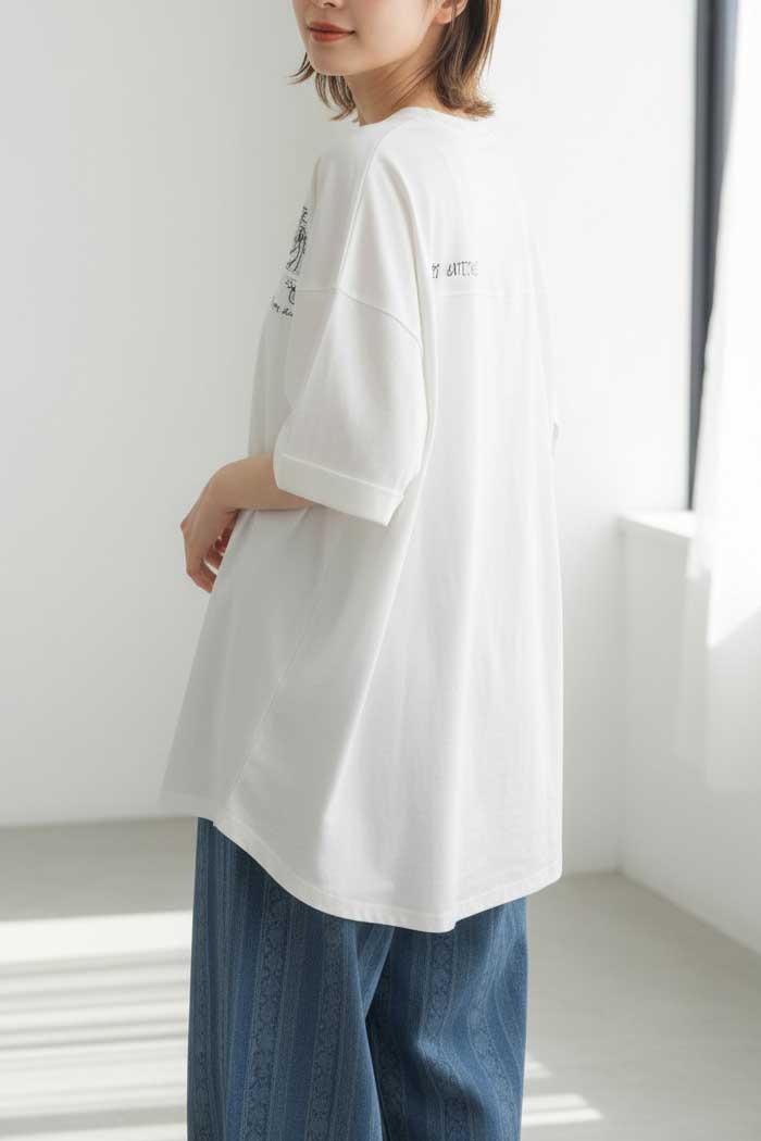 Mikonosublue Storeの猫プリント入り白チュニックTシャツ。前後差のある裾とドロップショルダーが特徴の綿100%素材。