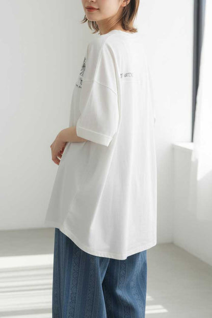 Mikonosublue Storeの猫プリント入り白チュニックTシャツ。前後差のある裾とドロップショルダーが特徴の綿100%素材。