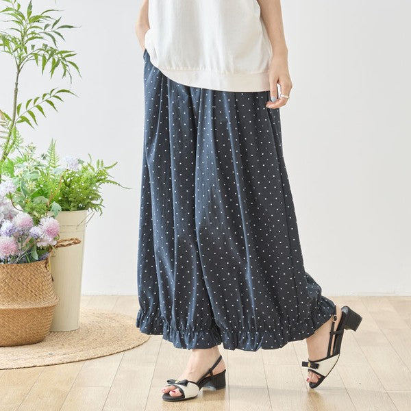 Mikonosublue Storeのネイビー地に白のピンドット柄が上品な裾フリル付きワイドパンツ。ゆったりとしたシルエットで体型カバーも叶うポリエステル素材のボトムス。