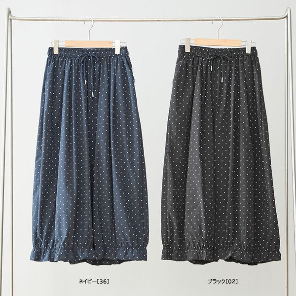 Mikonosublue Storeのネイビーとブラックのピンドット柄ワイドパンツ。裾にギャザーフリルをあしらったポリエステル素材のゆったりとしたボトムス。