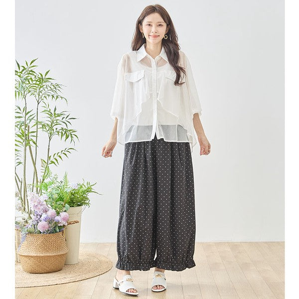 Mikonosublue Storeのピンドット柄ワイドパンツ。裾フリルが特徴のゆったりとしたポリエステル製ボトムスを着用した女性