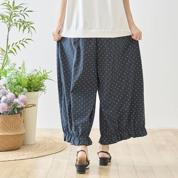 Mikonosublue Storeのピンドット柄ワイドパンツ。裾のギャザーフリルが特徴的な、ゆったりとしたシルエットのネイビーのポリエステル製ボトムス。