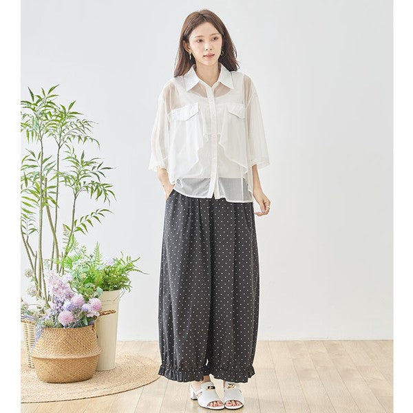 Mikonosublue Storeのピンドット柄ワイドパンツ。裾のフリルとゆったりしたシルエットが特徴のポリエステル製ボトムス。