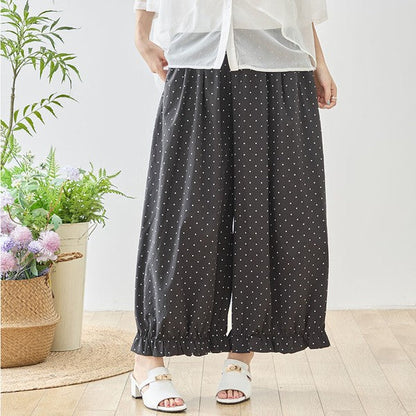 Mikonosublue Storeのピンドット柄ワイドパンツ。裾にギャザーフリルをあしらったダークトーンのポリエステル製ゆったりパンツ。