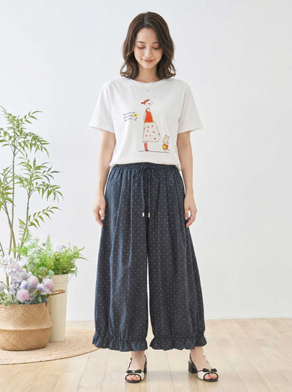 Mikonosublue Storeのピンドット柄ワイドパンツ。裾のギャザーフリルが特徴的なネイビーのポリエステル製パンツを着用したモデル。