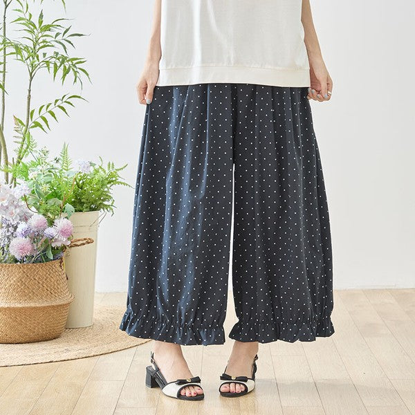 Mikonosublue Storeのピンドット柄ワイドパンツ。裾にギャザーフリルをあしらったネイビーのゆったりとしたポリエステル製ボトムス。