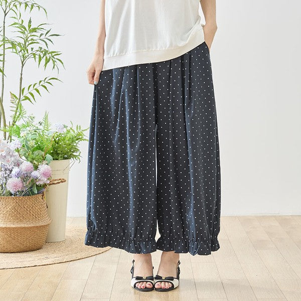 Mikonosublue Storeのネイビー地に白のピンドット柄が上品な、裾フリル付きワイドパンツ。ゆったりとしたシルエットで体型カバーも叶うフェミニンなデザイン。
