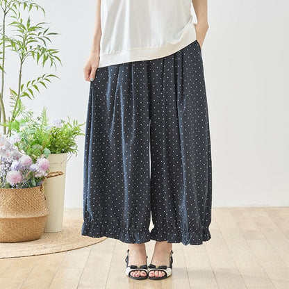 Mikonosublue Storeのネイビー地に白のピンドット柄が上品な、裾フリル付きワイドパンツ。ゆったりとしたシルエットで体型カバーも叶うフェミニンなデザイン。