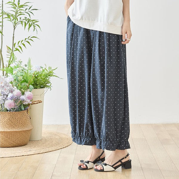Mikonosublue Storeのネイビー地に白のピンドット柄が上品な裾フリル付きワイドパンツ。ゆったりとしたシルエットで体型カバーも叶うポリエステル素材のボトムス。