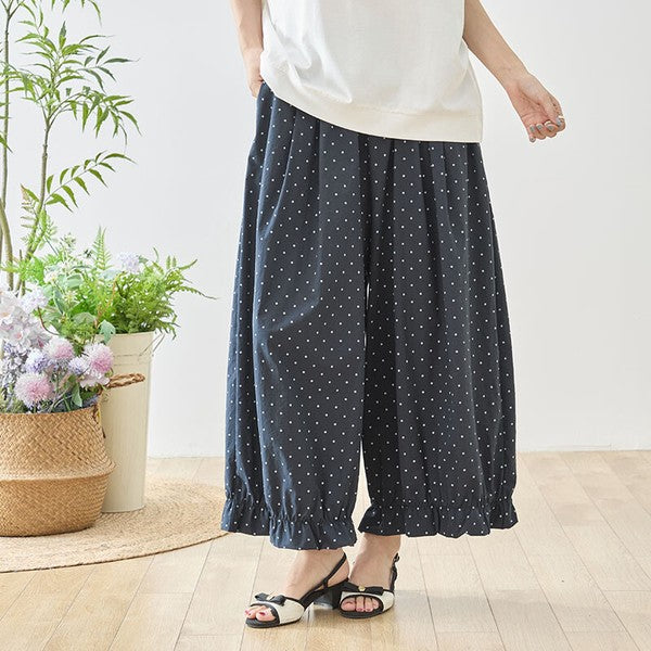Mikonosublue Storeのピンドット柄ワイドパンツ。裾にギャザーフリルをあしらったネイビーのポリエステル製ゆったりパンツ。