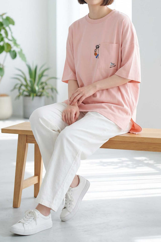 Mikonosublue Storeのピンク色の綿100%半袖Tシャツ。胸ポケットにアニマル刺繍があり、ゆったりとしたドロップショルダーのシルエットでサイドスリット入り。