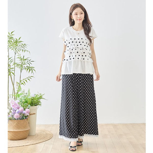 Mikonosublue Storeのポルカドット柄ワイドパンツ。裾に白いクロシェレースをあしらった黒のゆったりとしたシルエットで、体型カバーも叶う大人可愛いデザイン。
