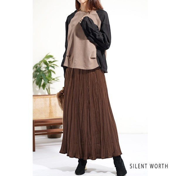 Mikonosublue Store beige and black raglan pullover with voluminous pleated sleeves paired with a brown pleated skirt
