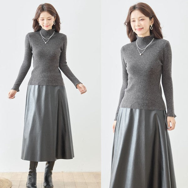 Mikonosublue Storeのチャコールグレーのリブニットプルオーバー。ハイネックと袖口のフリルが特徴で、女性らしいシルエットの長袖インナー。