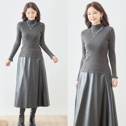 Mikonosublue Storeのチャコールグレーのリブニットプルオーバー。ハイネックと袖口のフリルが特徴で、女性らしいシルエットの長袖インナー。
