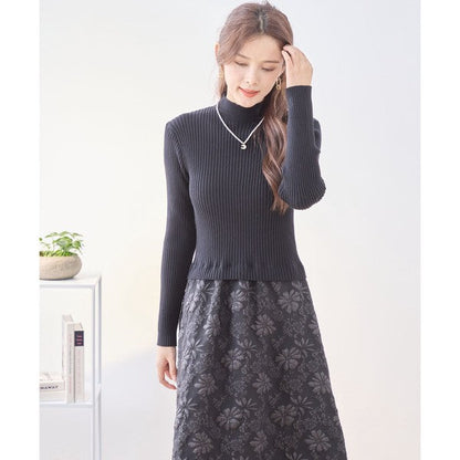 Mikonosublue Storeの黒いリブニットと花柄ふくれジャガードスカートがドッキングされた上品な長袖ワンピース