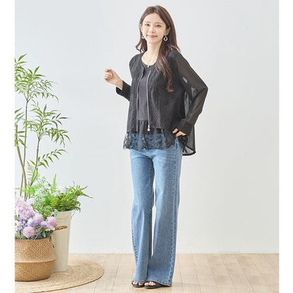 Mikonosublue Storeの黒いシアーレースジャケット。フラワーカットワークとパールボタンが特徴のバックロング丈ライトアウターを着用した女性。