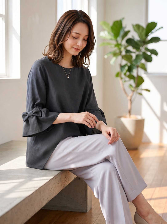 Mikonosublue Storeの袖リボン付き七分袖チュニックブラウス。黒のポリエステル素材でふんわりとしたAラインシルエットが特徴。