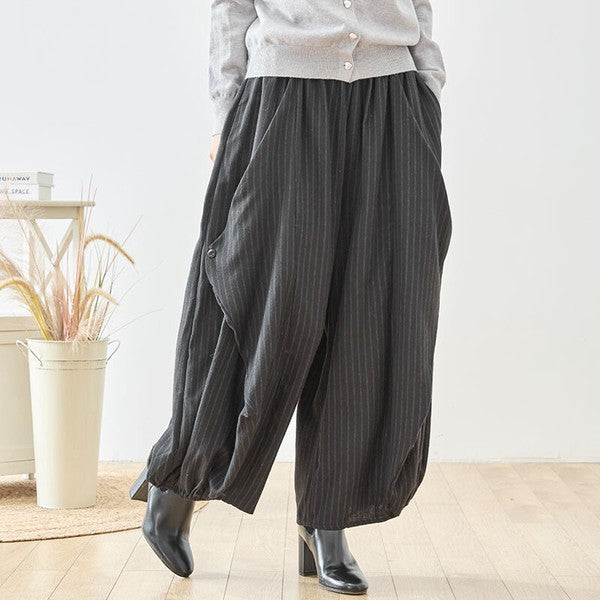 Mikonosublue Storeの黒いストライプ柄バルーンパンツ。ゆったりとしたワイドシルエットで体型カバーも叶うポリエステル素材のカジュアルパンツ。