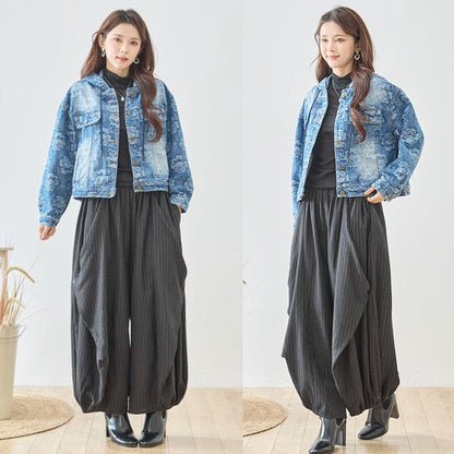 Mikonosublue Storeの黒いストライプ柄バルーンパンツを着用した女性。ゆったりとしたワイドシルエットで体型カバーも叶う秋のカジュアルコーデ。