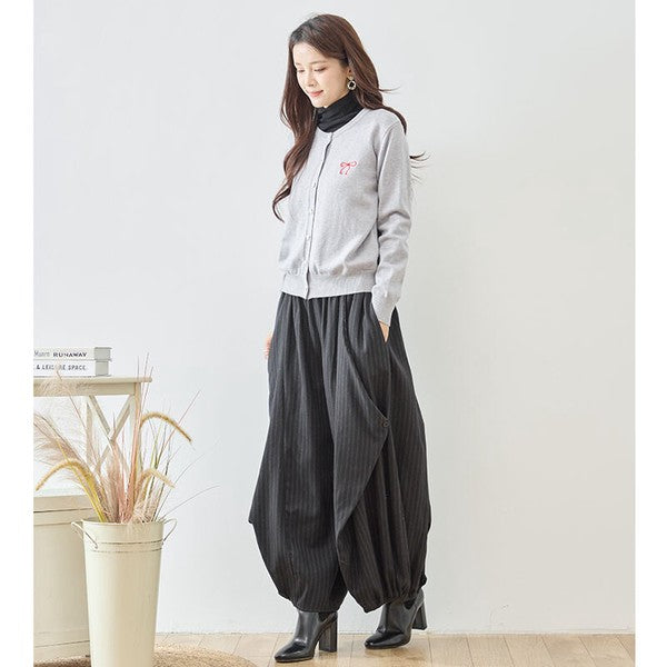 Mikonosublue Storeのストライプ柄バルーンパンツを着用した女性。ゆったりとしたコクーンシルエットで体型カバーも叶うカジュアルな秋の装い。