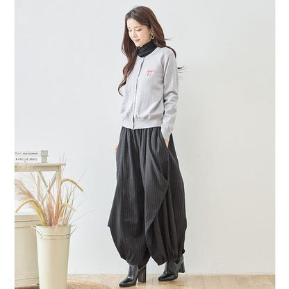 Mikonosublue Storeのストライプ柄バルーンパンツを着用した女性。ゆったりとしたコクーンシルエットで体型カバーも叶うカジュアルな秋の装い。