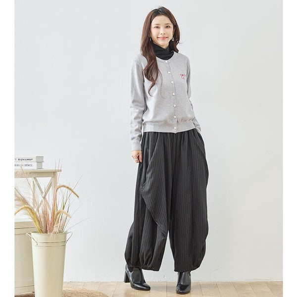 Mikonosublue Storeの黒いストライプ柄バルーンパンツを着用した女性。ふんわりとしたワイドなシルエットで体型をカバーする秋のカジュアルコーデ。