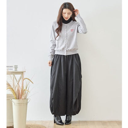 Mikonosublue Storeのストライプ柄バルーンパンツを着用した女性。ゆったりとしたコクーンシルエットで体型カバーも叶う秋のカジュアルスタイル。