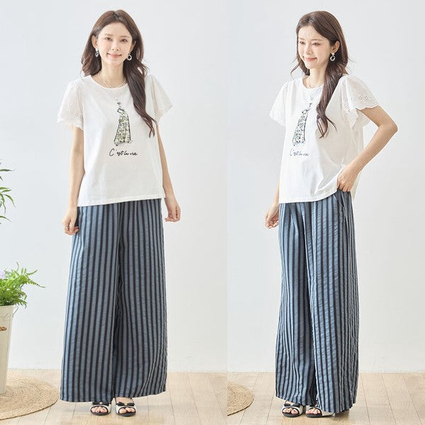 Mikonosublue Storeのストライプ柄ワイドパンツを着用した女性。ウエストゴムでゆったりとしたシルエットの美脚パンツ。