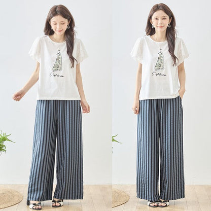 Mikonosublue Storeのストライプ柄ワイドパンツを着用した女性。ウエストゴムでゆったりとしたシルエットの美脚パンツ。