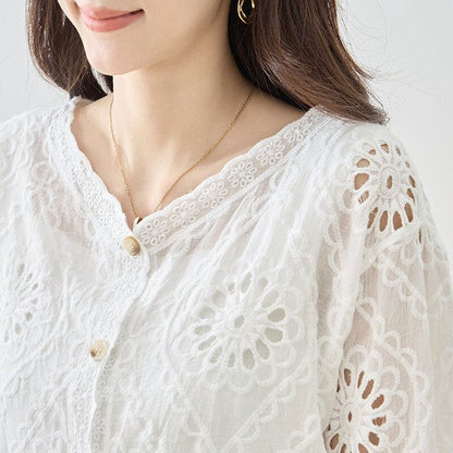 Mikonosublue Storeの白いコットン製カットワーク刺繍ブラウス。Vネックと七分袖が特徴の涼しげな夏用トップス。