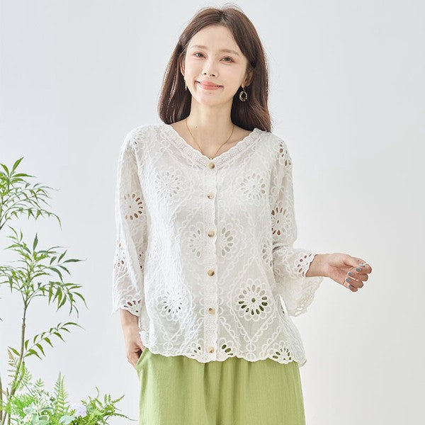 Mikonosublue Storeの白いコットン製カットワーク刺繍ブラウス。Vネックと七分袖で涼しげなデザイン。