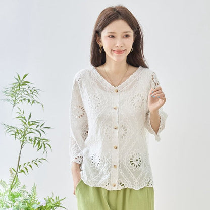 Mikonosublue Storeの白いコットン製カットワーク刺繍ブラウス。Vネックと七分袖で涼しげなデザイン。