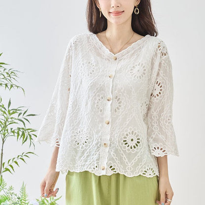 Mikonosublue Storeの白いコットン製カットワーク刺繍ブラウス。Vネックと七分袖が特徴の涼しげな夏用トップス