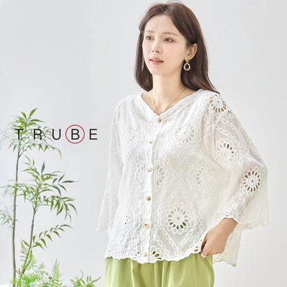 Mikonosublue Storeの白いコットン製カットワーク刺繍ブラウス。Vネックと七分袖で涼しげな透け感のあるデザイン。