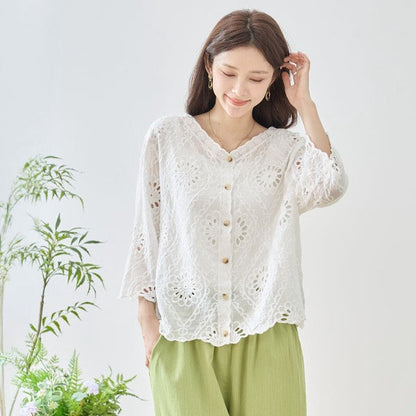 Mikonosublue Storeの白いコットン製カットワーク刺繍ブラウス。Vネックと七分袖で涼しげなデザイン。