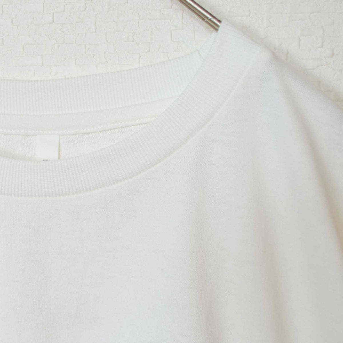 Mikonosublue Storeの綿100%素材を使用した、ゆったりとしたシルエットの白い半袖チュニックTシャツのネックライン