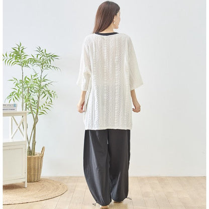 Mikonosublue Storeのアイレット透かし模様が涼しげなホワイトのビッグシルエットトップスを着用した女性の後ろ姿