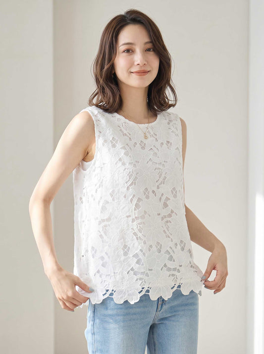 Mikonosublue Storeの白い花柄カットワークレースノースリーブトップス。裾はスカラップ仕様で、ゆったりとしたシルエットが特徴。