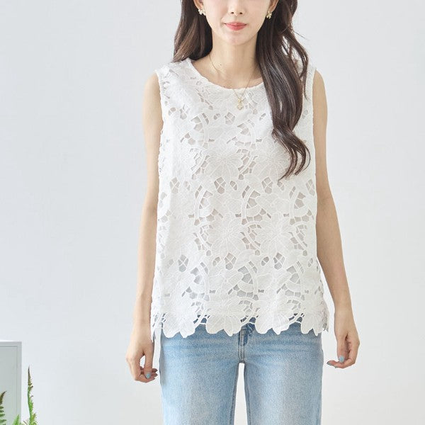 Mikonosublue Storeの白い花柄カットワークレースノースリーブトップス。裾はスカラップ仕様で、ゆったりとしたシルエットが特徴。