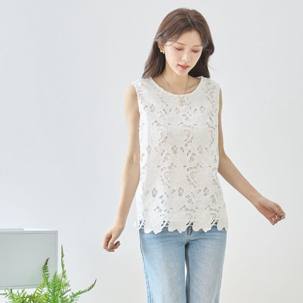 Mikonosublue Storeの白い花柄カットワークレースノースリーブトップス。裾はスカラップ仕様で、デニムと合わせた上品な大人カジュアルスタイル。