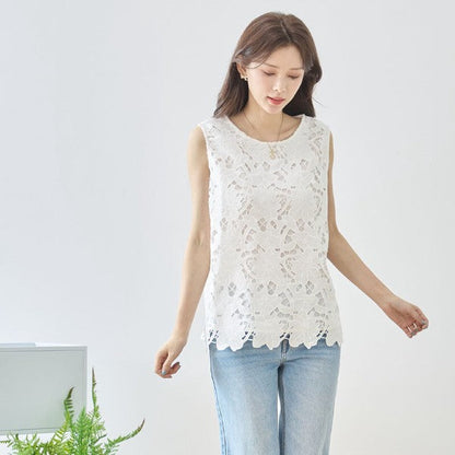 Mikonosublue Storeの白い花柄カットワークレースノースリーブトップス。裾はスカラップ仕様で、デニムと合わせた上品な大人カジュアルスタイル。