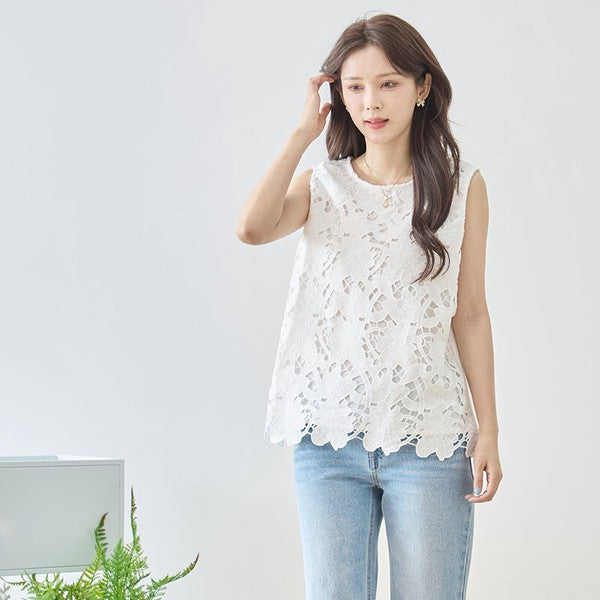 Mikonosublue Storeの白いフラワーカットワークレースのノースリーブトップス。裾はスカラップ仕様で、ゆったりとしたシルエットが特徴。